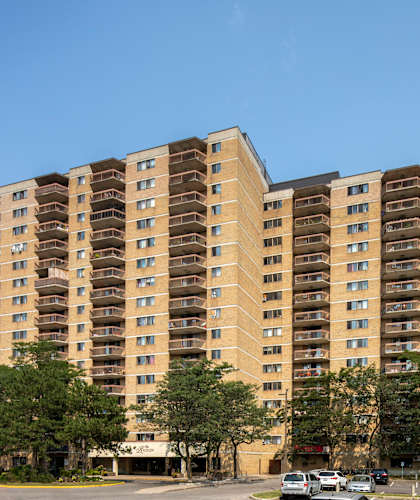 A large apartment building with a parking lot in front.