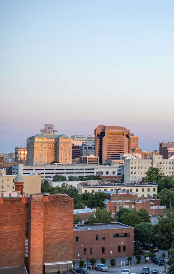 A cityscape with buildings and trees in the foreground.