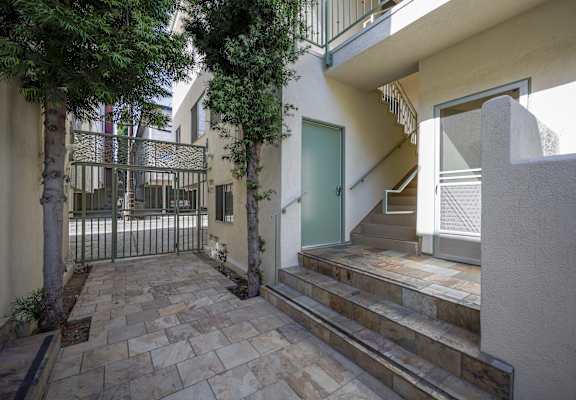 the front door of a house with stairs and a courtyard