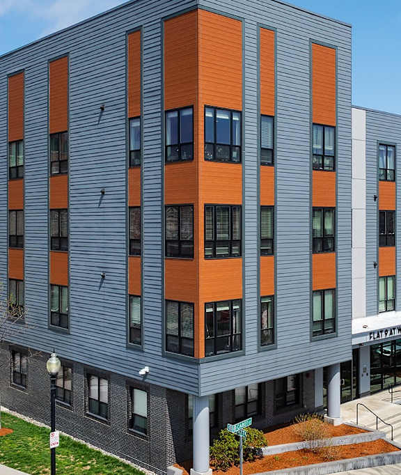 A modern building with a grey and orange facade.