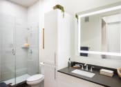 Thumbnail 10 of 19 - a bathroom with white walls and a black countertop