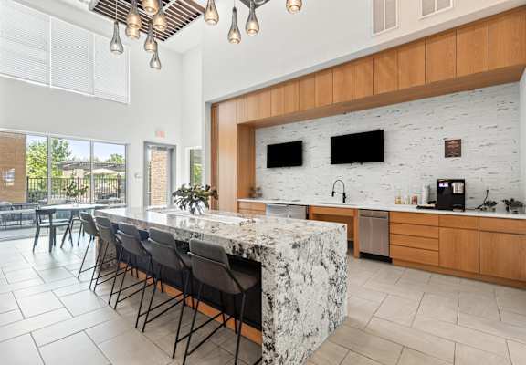 A kitchen with a marble island and wooden cabinets.