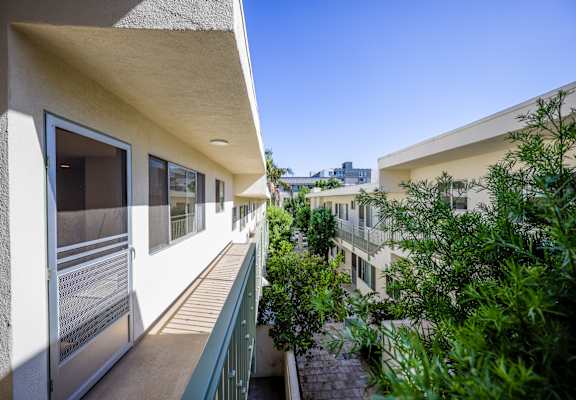 a balcony with a view of a building and some trees