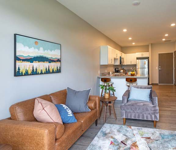 a living room with a couch and a chair and a kitchen