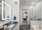 Thumbnail 14 of 19 - a bathroom with a tub and a shower with a glass door