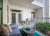 Thumbnail 9 of 19 - a living room with a couch and a coffee table on a balcony