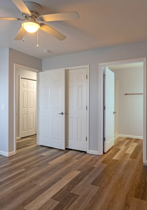 a living room with three doors and a ceiling fan