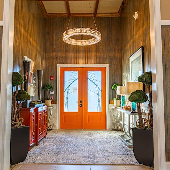 A hallway with a wooden wall and a red door.