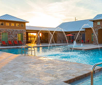 A pool with a slide and a building behind it.