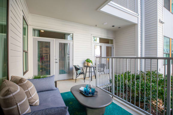 a living room with a couch and a coffee table on a balcony