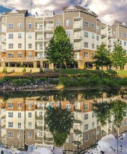 A large building with a pond in front of it.