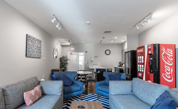a living room with couches and a coke machine
