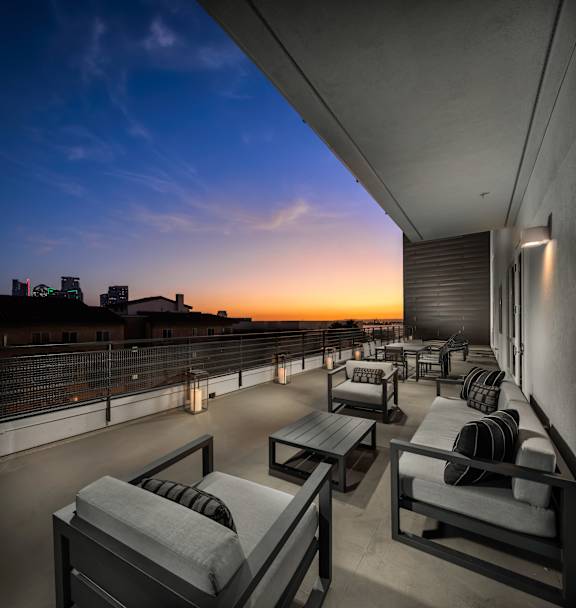 A balcony with chairs and a table is set up for relaxing.