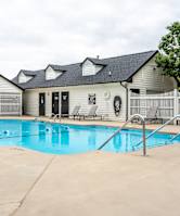 A large swimming pool in front of a house.