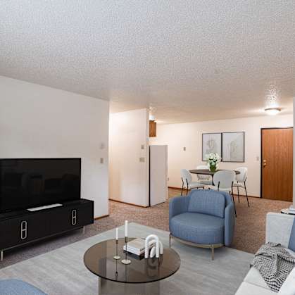 a living room with a couch and a table and a tv. Fargo, ND Monticello Apartments