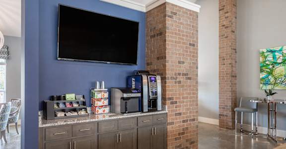 a living room with a blue wall and a counter with drinks and a television