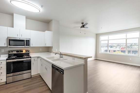 A modern kitchen with stainless steel appliances and white cabinets.