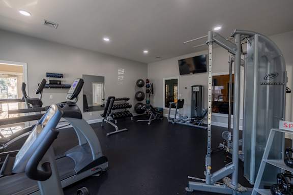 A spacious gym with treadmills, weights, and exercise equipment.