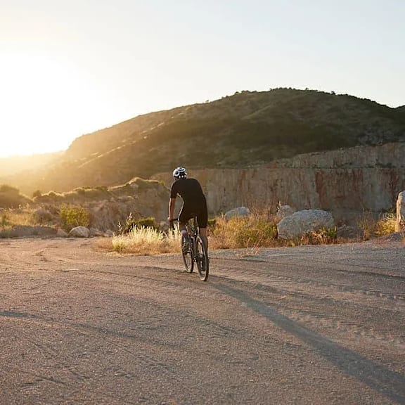 A person riding a bicycle on a dirt road.