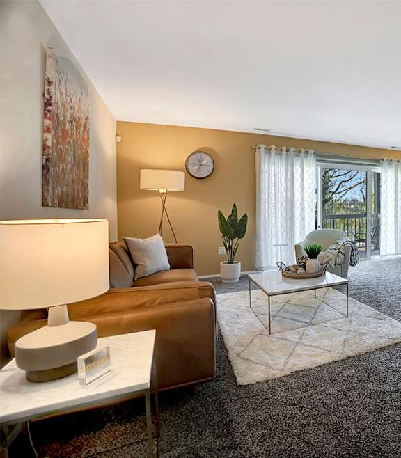 A modern living room with a blue couch and a coffee table. at Kenilworth at Charles Apartments, Towson, MD, 21204