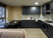 Thumbnail 1 of 8 - a small kitchen with black cabinets and a black dining table