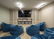 Thumbnail 3 of 8 - a room with blue pillows and a television on the wall