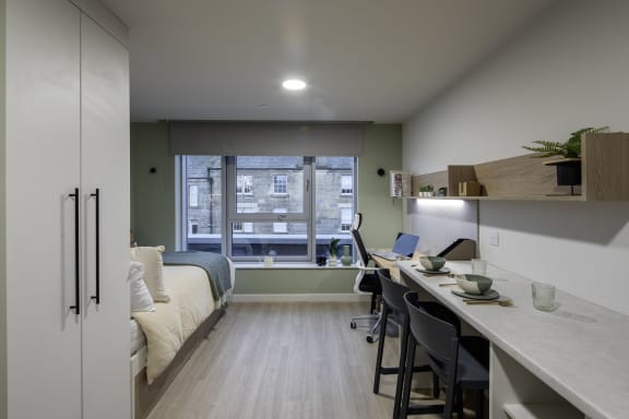 a home office with a desk in a room with a bed
