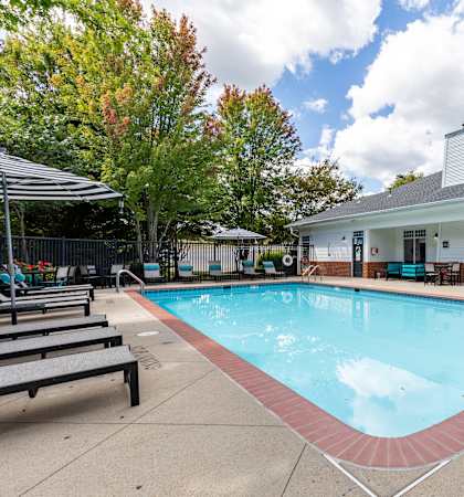 A small pool in front of a building with a blue sign.