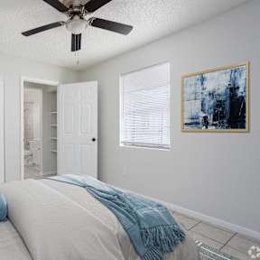 a bedroom with a large bed and a ceiling fan