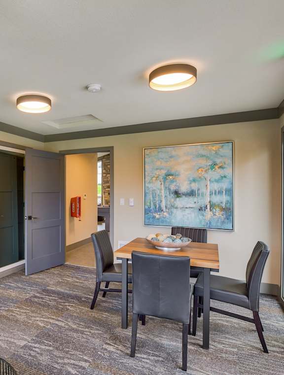 A dining room with a table set for four and a blue chair.