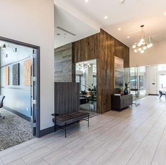 A modern office space with a glass wall and a wooden accent wall.