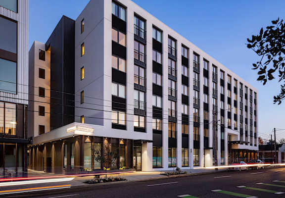 A modern multi-story building with black and white balconies.
