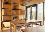 Thumbnail 3 of 8 - a dining area with a wooden table and chairs and a bookshelf