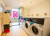 Thumbnail 4 of 8 - a washer and dryer room with a row of washing machines