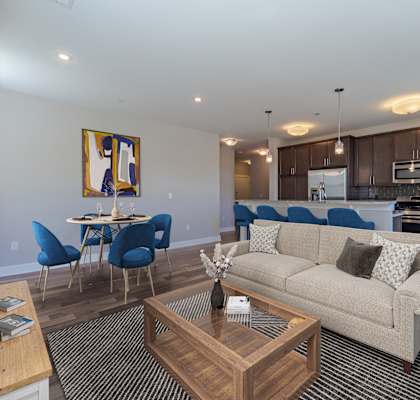 A living room with a couch, chairs, and a coffee table.