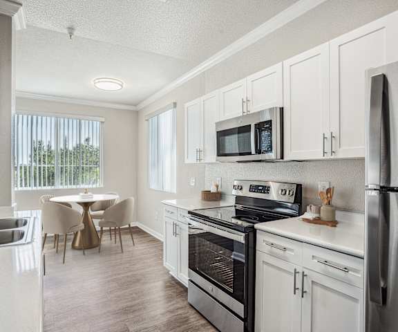 A kitchen with white cabinets and stainless steel appliances.