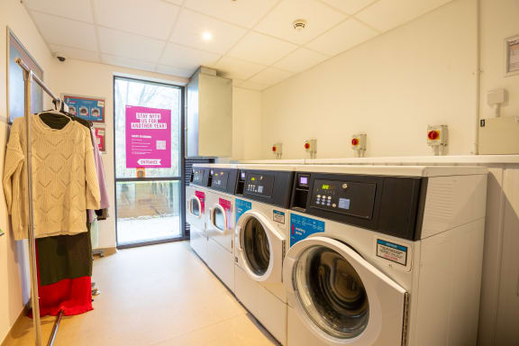 a washer and dryer room with a row of washing machines