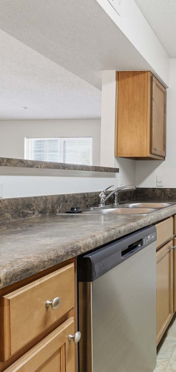 A kitchen with a black stove top oven, a microwave, and a black refrigerator.