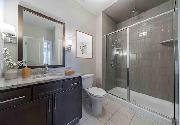 A bathroom with a toilet, sink, and shower.