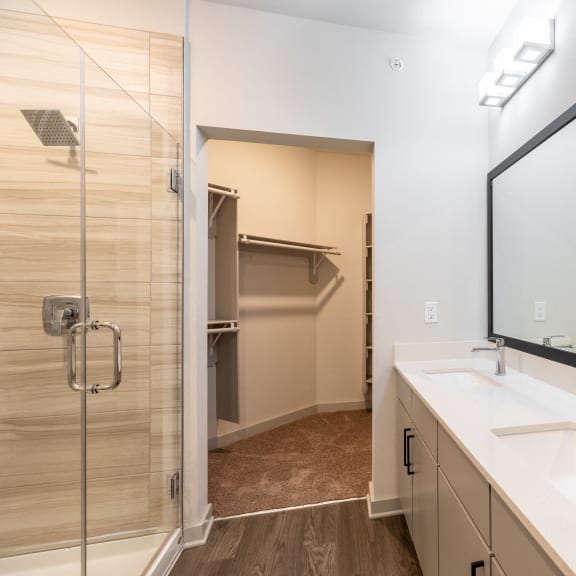 a bathroom with a large mirror and a sink and a shower