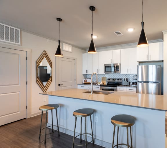 a kitchen with white cabinets and a white island with a sink