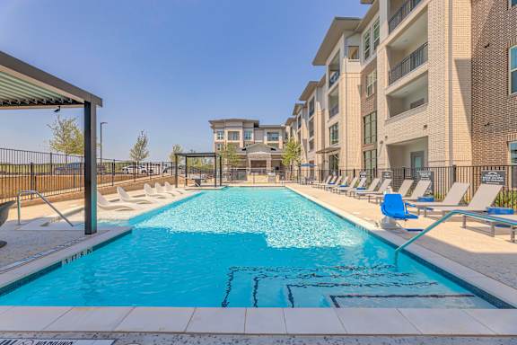 A swimming pool in front of apartment buildings.