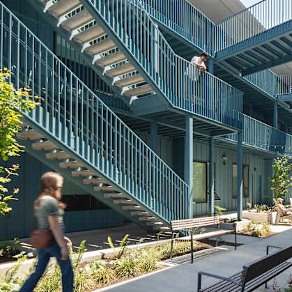 A woman is walking down a staircase in a modern building.
