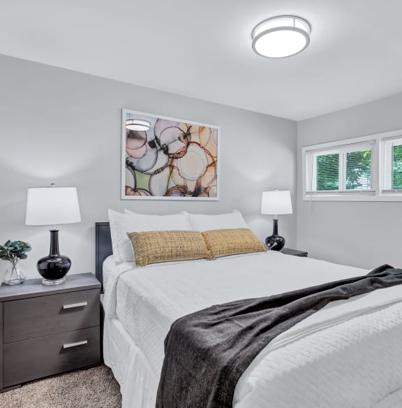 a bedroom with a white bed and two windows