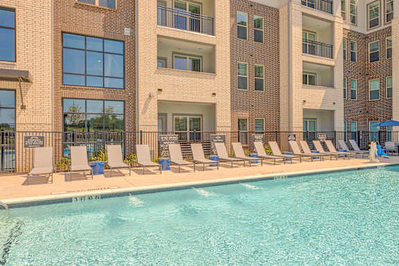 A swimming pool in front of apartment buildings.