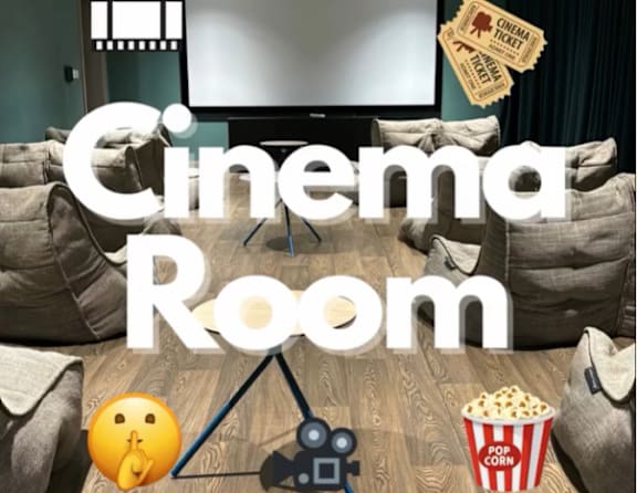 A cozy cinema room with a large screen, popcorn, and a clapperboard.