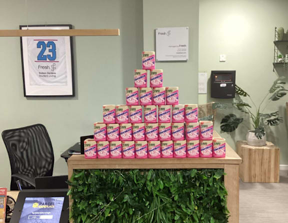 A table with a stack of pink boxes on top of it.