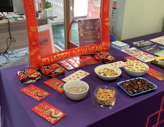 A table with a purple cloth and red decorations is set up for a New Year celebration.