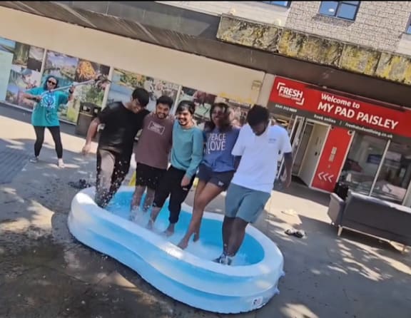 A group of people are playing in an inflatable water slide.
