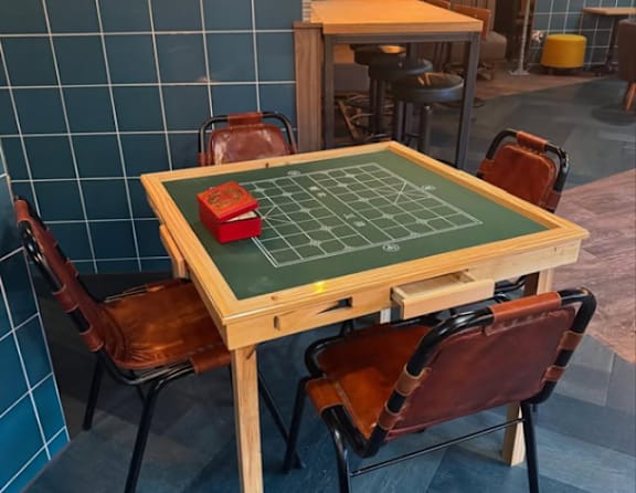 A table with a green board and four chairs.